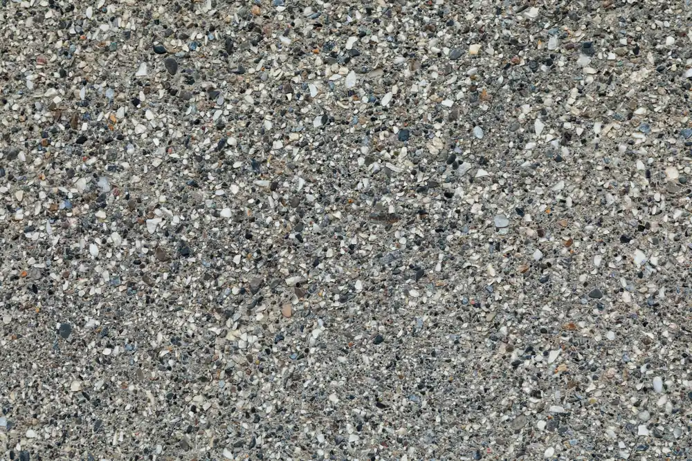 Top-down view of exposed aggregate concrete with small gray, tan and dark pebbles