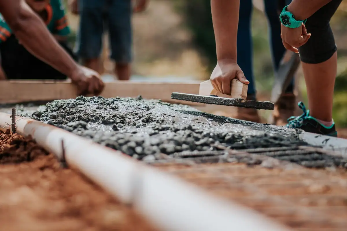 Hand float smoothing freshly placed concrete inside wood forms
